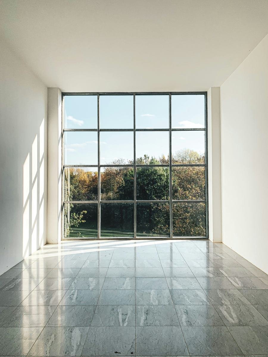 Sala vacía con piso de mármol y ventanal de piso a techo